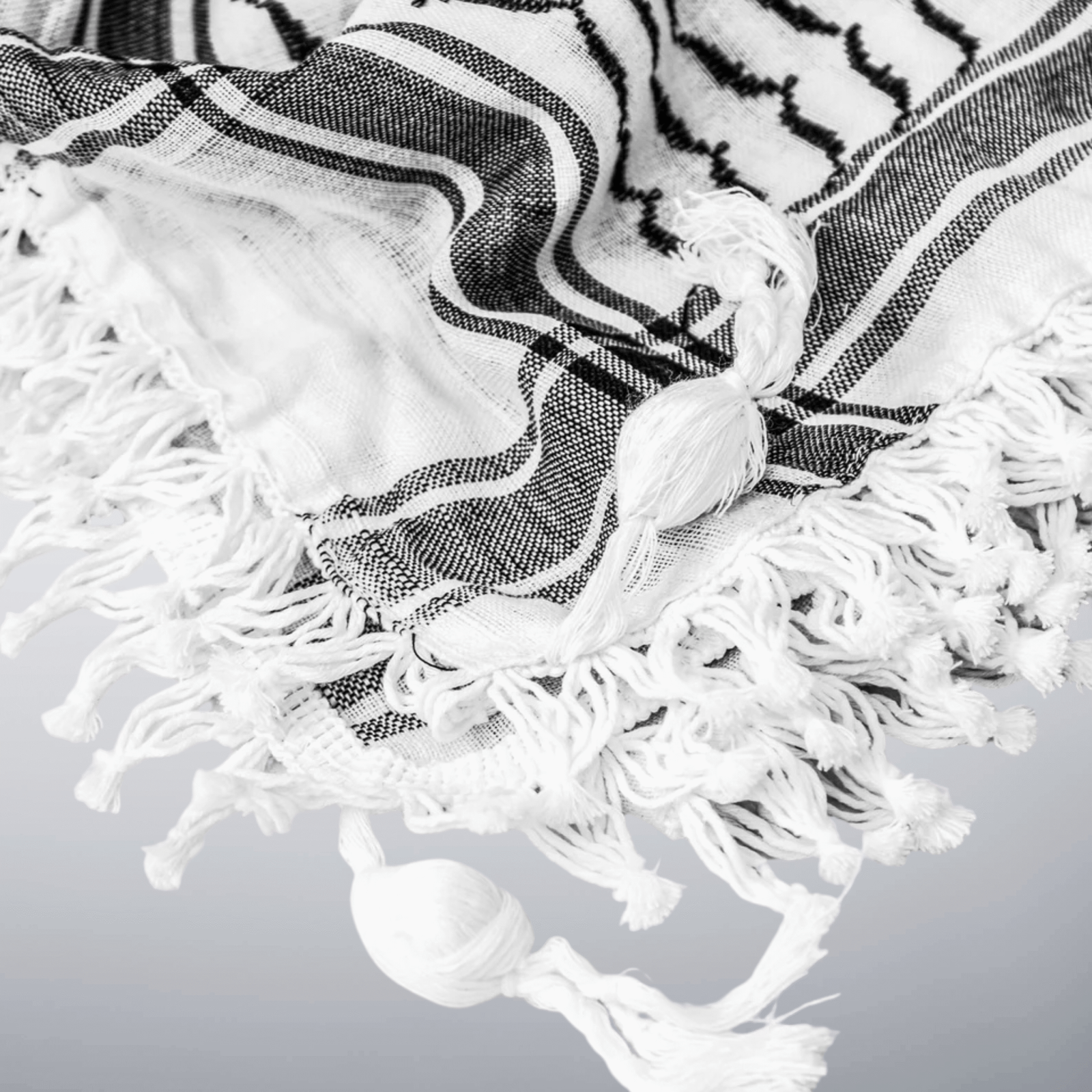 classic black and white keffiyeh close up showing tassels.