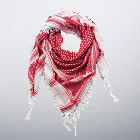 Red and white Palestinian keffiyeh with tassels, styled in a soft loop.