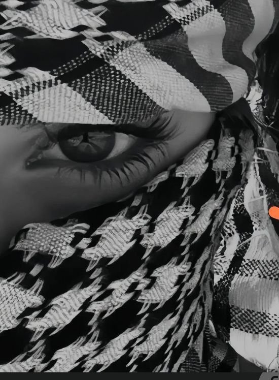 A selfie of a female wrapped with a keffiyeh showing her eye and the fine keffiyeh details.