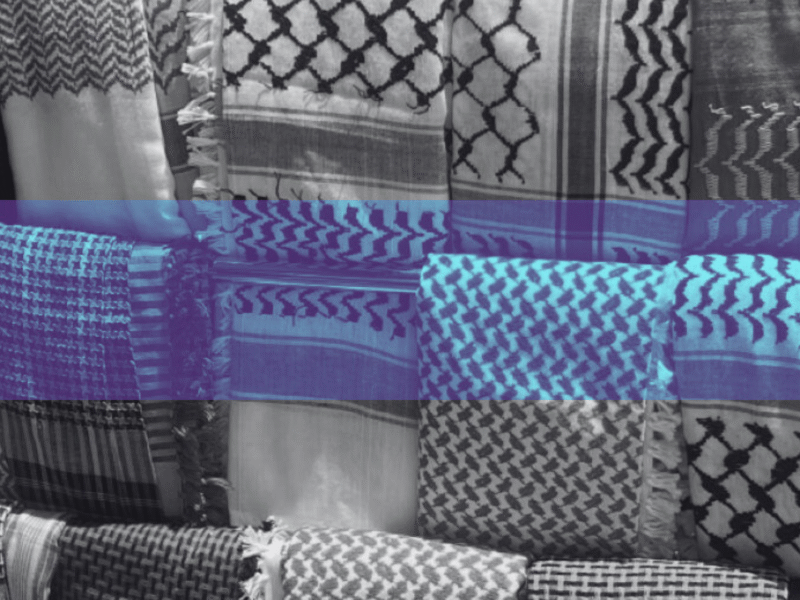 Display of black and white keffiyeh patterns stacked in a shop