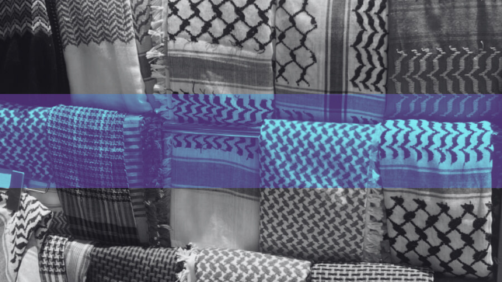 Display of black and white keffiyeh patterns stacked in a shop