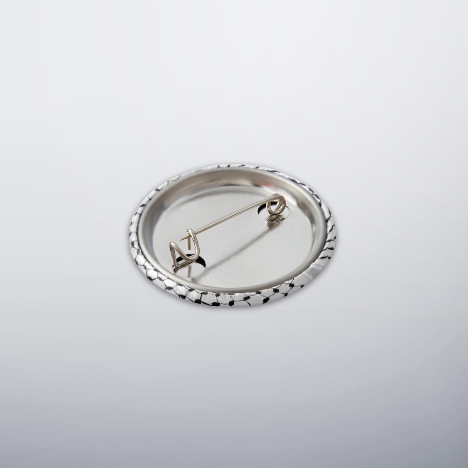Back of keffiyeh button pin showing metal safety pin fastening