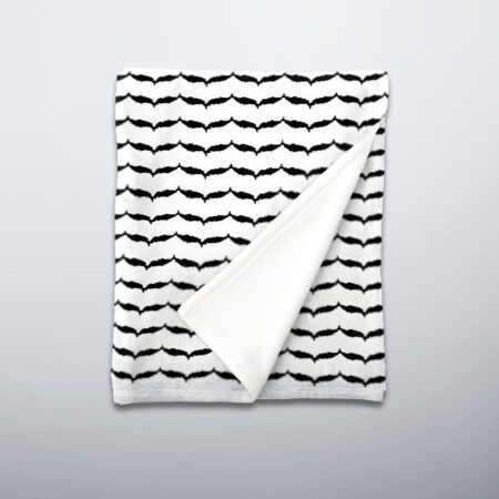 Folded keffiyeh fleece blanket showing patterned front and off white back