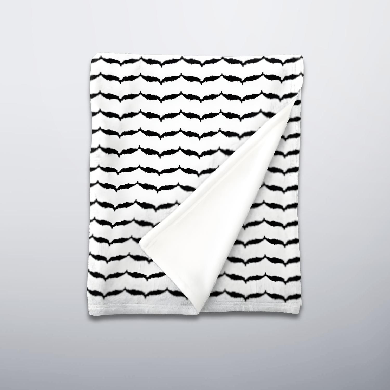 Folded keffiyeh fleece blanket showing patterned front and off white back